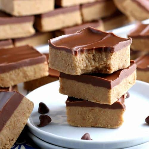 Stack of three chocolate topped peanut butter bars with one on the side.