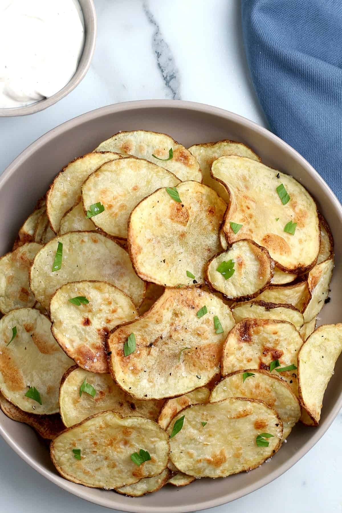 Overhead view of golden potato chips in a bowl