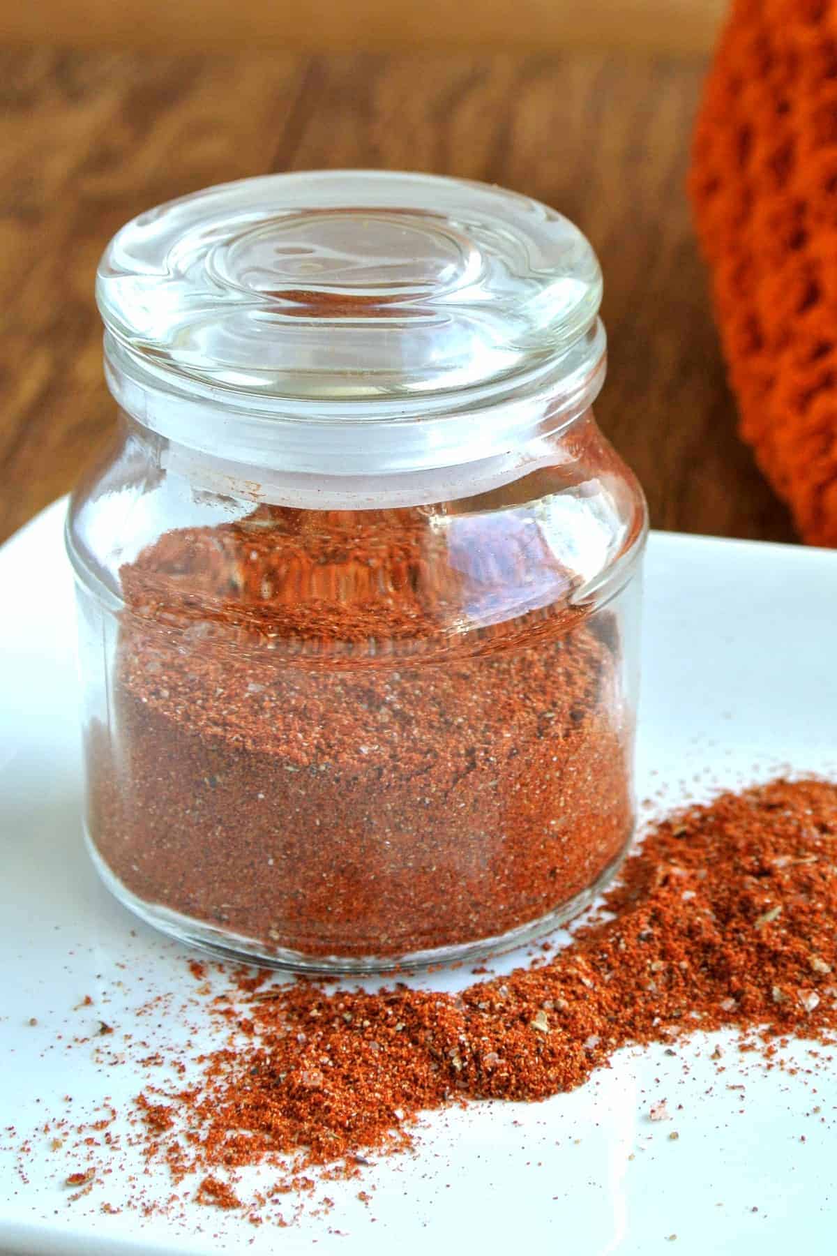 Cropped photo of a glass jar filled with this homemade taco seasoning recipe.