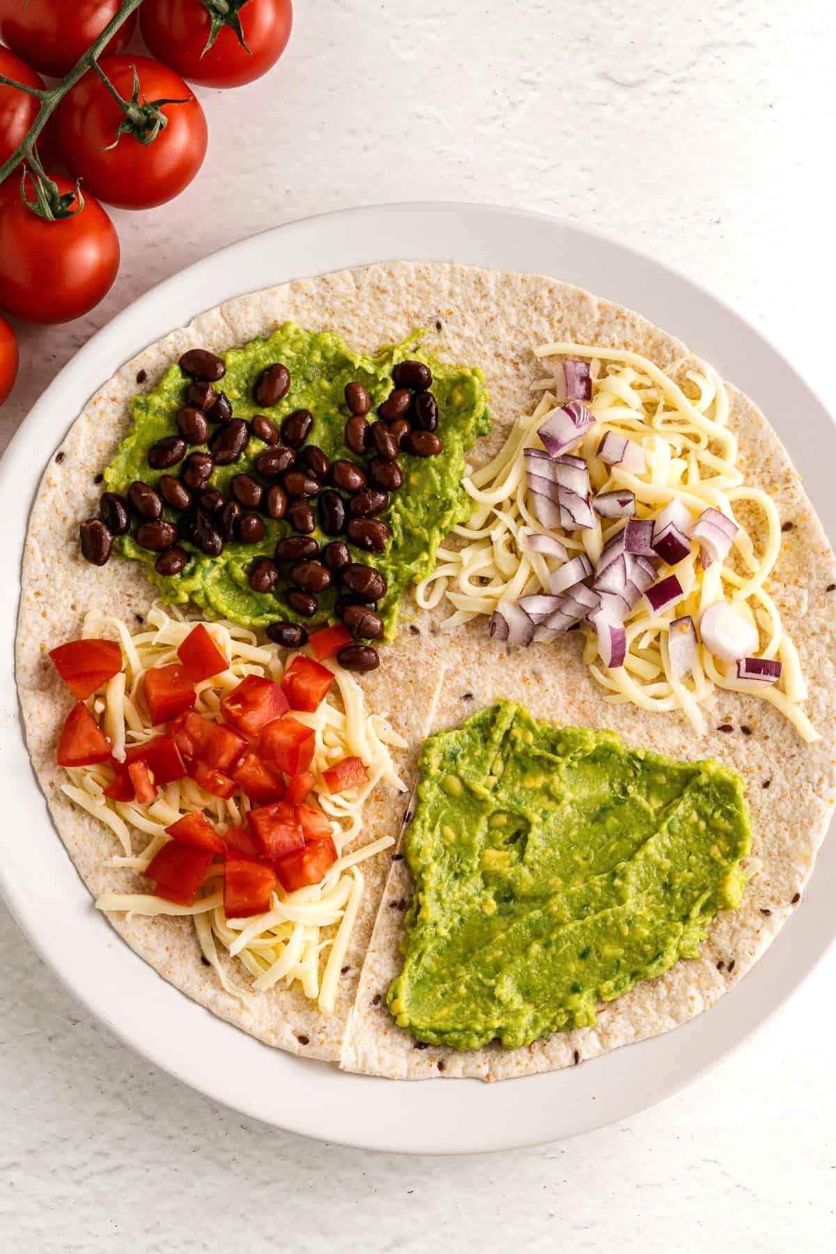 A tortilla filled with veggies and ready to be folded.