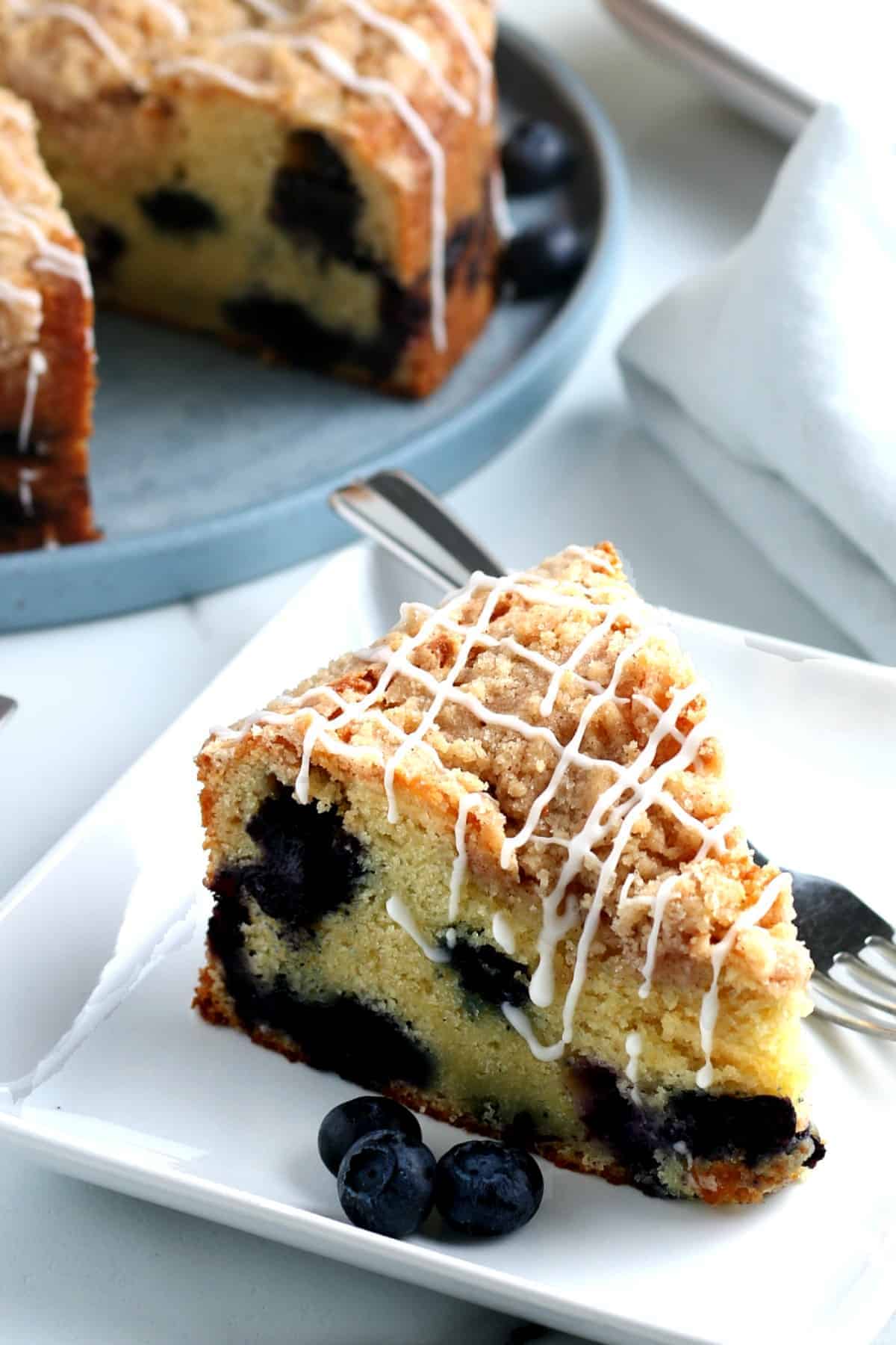 Close up of a lemon blueberry coffee cake siting on a small plate.