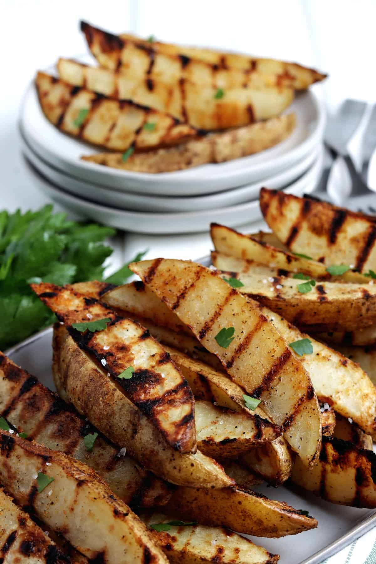 Close up angled photo of golden brown veggies stacked with small plates behind,