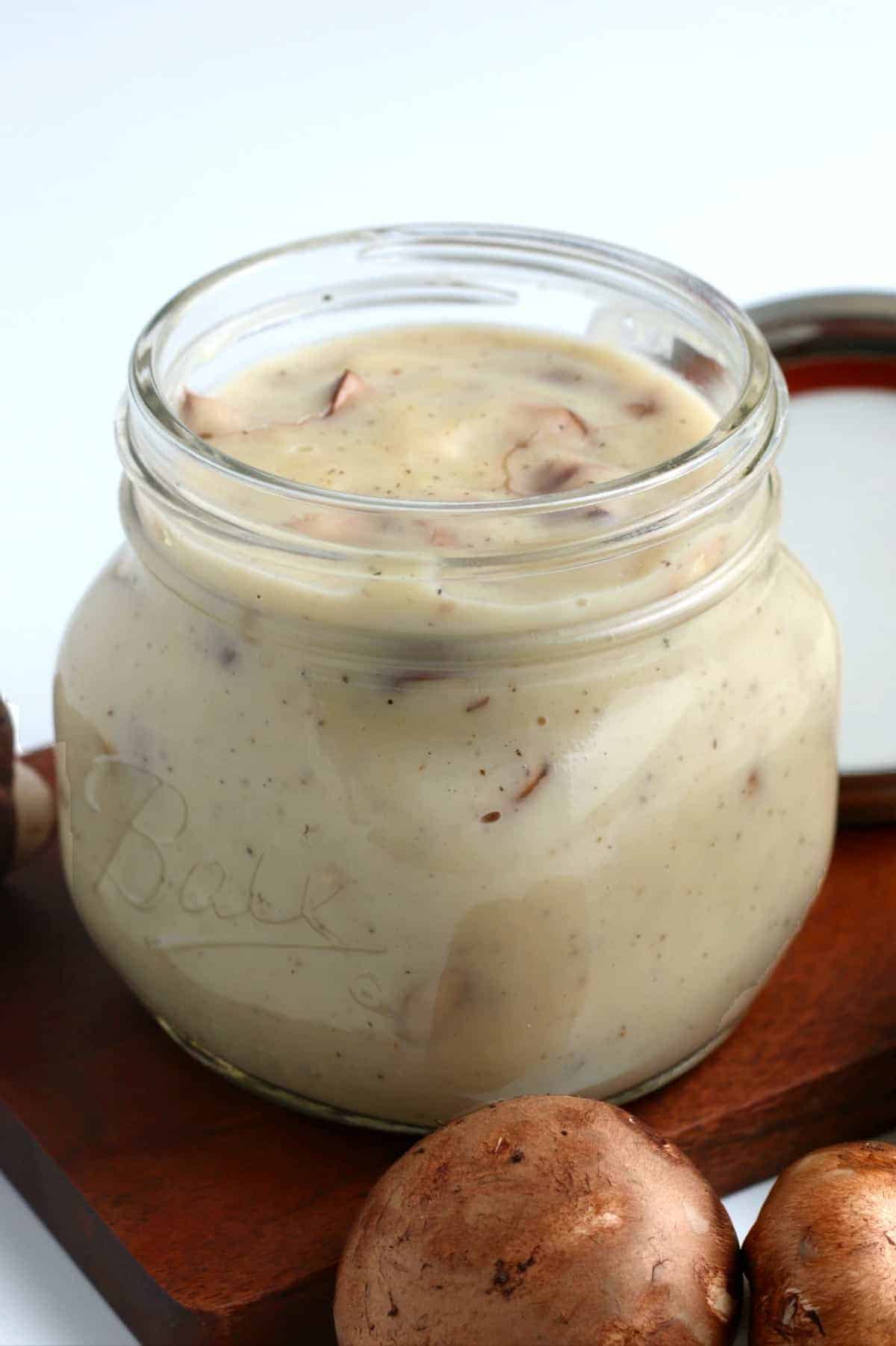 Pint jar filled with homemade comfort food with mushrooms on the side.