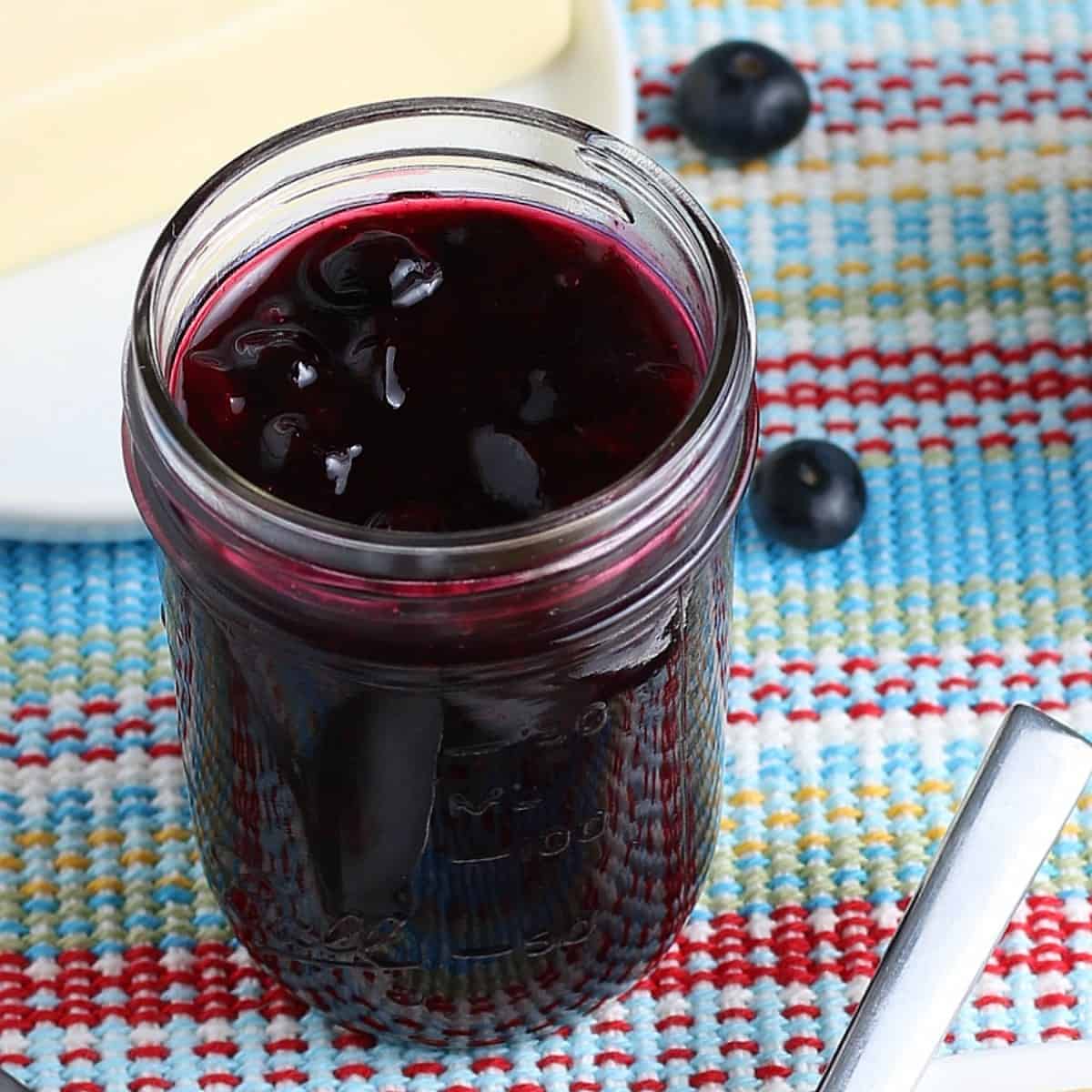 A pint jar filled with a cooked fruit condiment.