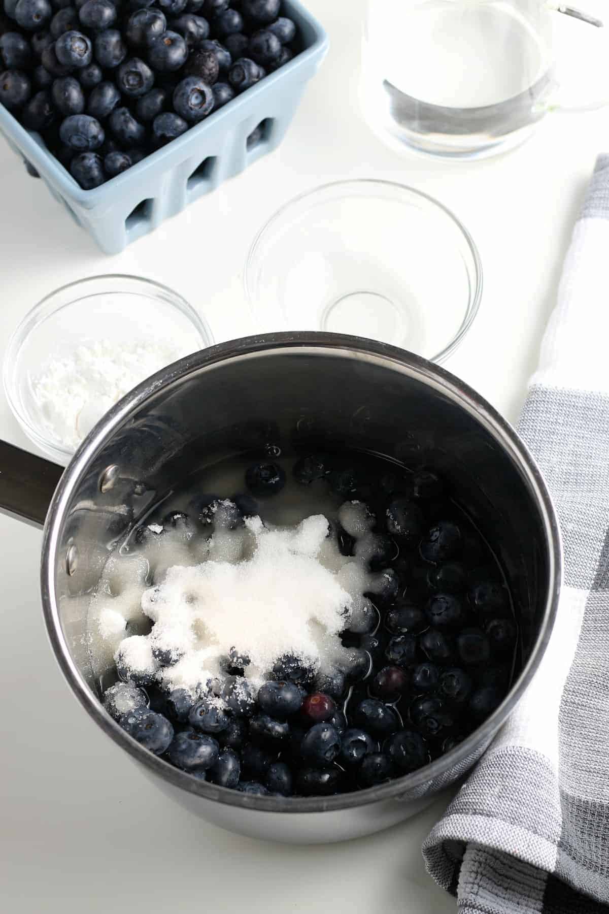Blueberries and sugar in a saucepan ready to be cooked.