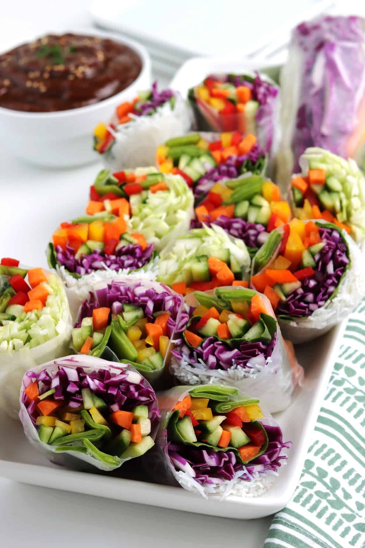 Platter of Vietnamese summer rolls and a bowl full of peanut dipping sauce.