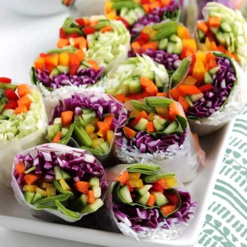 Close photo of sliced halves of summer rolls with lots of veggies.