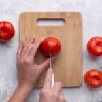 Make an X mark on bottom of each tomato