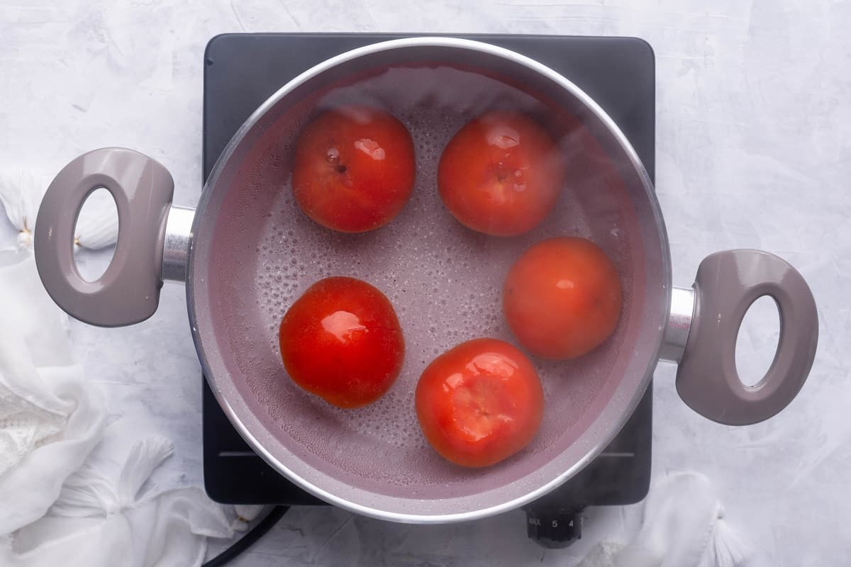 Add tomatoes to simmering water
