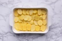 Layer potatoes in casserole dish overlapping in staggered type of style