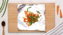 Divide the vegetables by four and place in the center of each foil square