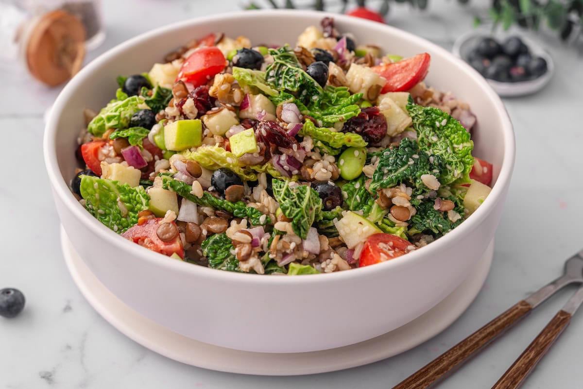 a large bowl of superfood salad featuring many different colors and textures from fruits, vegetables, and grains.