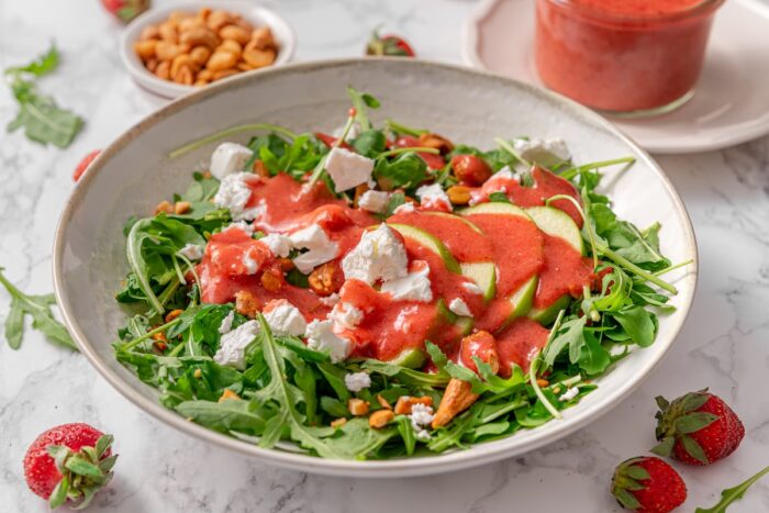 homemade strawberry vinaigrette is drizzled over a simple homemade salad